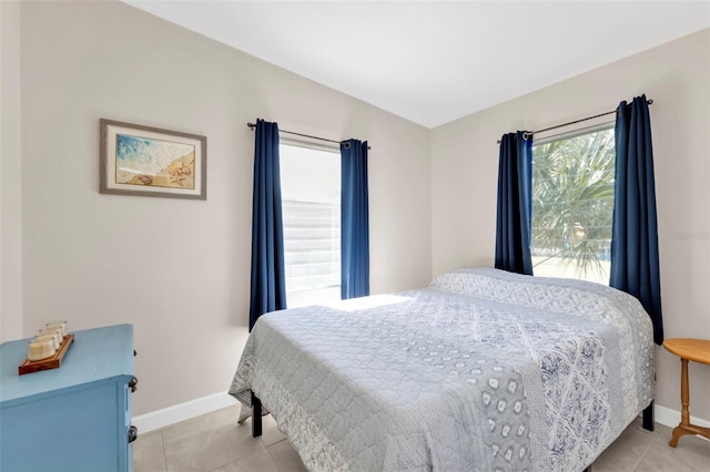 bedroom with light tile patterned flooring and baseboards