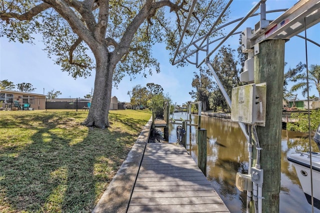 dock area featuring a yard, a water view, and boat lift