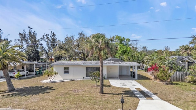 view of front of house with an attached carport, driveway, and a front lawn