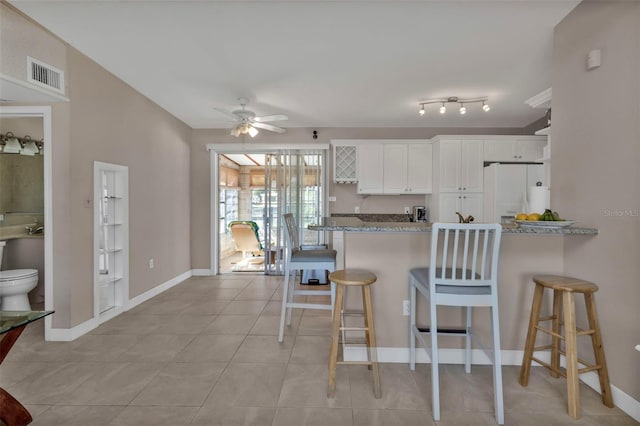 3627 Easy St, Port Charlotte, FL 33952 - kitchen featuring white fridge with ice dispenser, a ceiling fan, a breakfast bar, and a peninsula