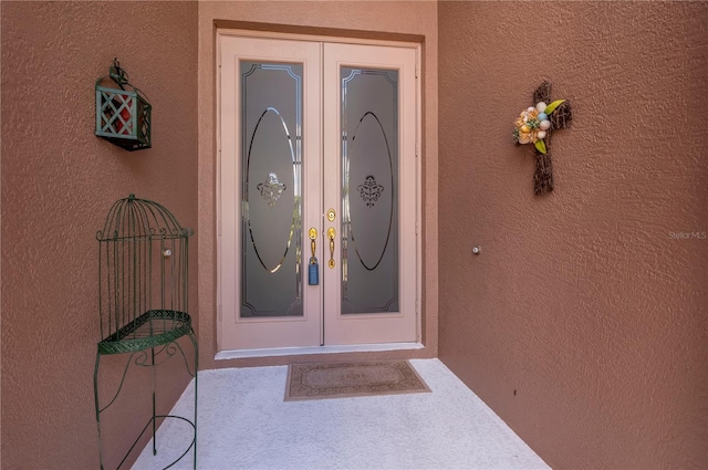 doorway to property featuring french doors and stucco siding