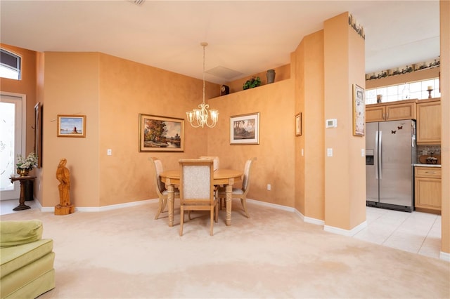 dining area with a notable chandelier, light tile patterned floors, baseboards, and light colored carpet