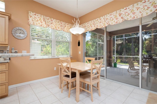 dining space featuring a sunroom and light tile patterned flooring