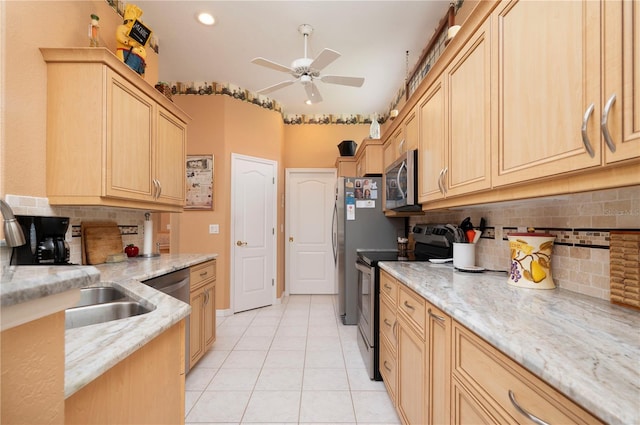 kitchen with stainless steel appliances, light brown cabinets, and light stone countertops