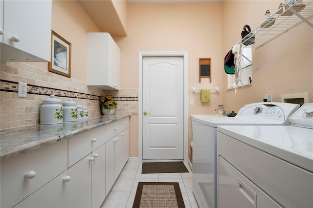 laundry room featuring cabinet space, washer and clothes dryer, and light tile patterned flooring