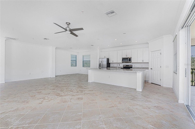 kitchen featuring visible vents, an island with sink, appliances with stainless steel finishes, open floor plan, and white cabinetry