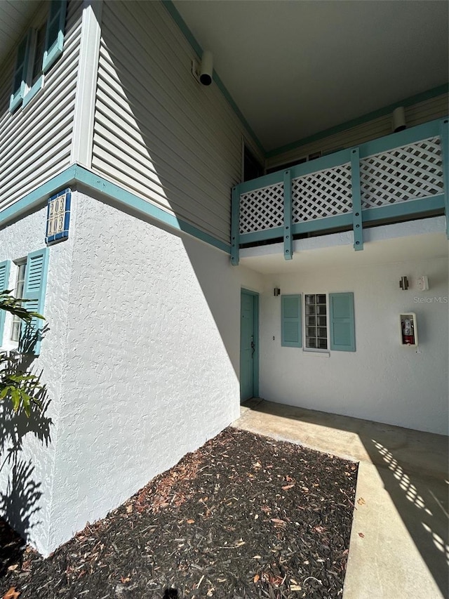 doorway to property featuring stucco siding