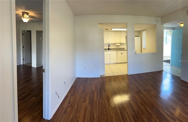 unfurnished room featuring a sink, a textured ceiling, and wood finished floors