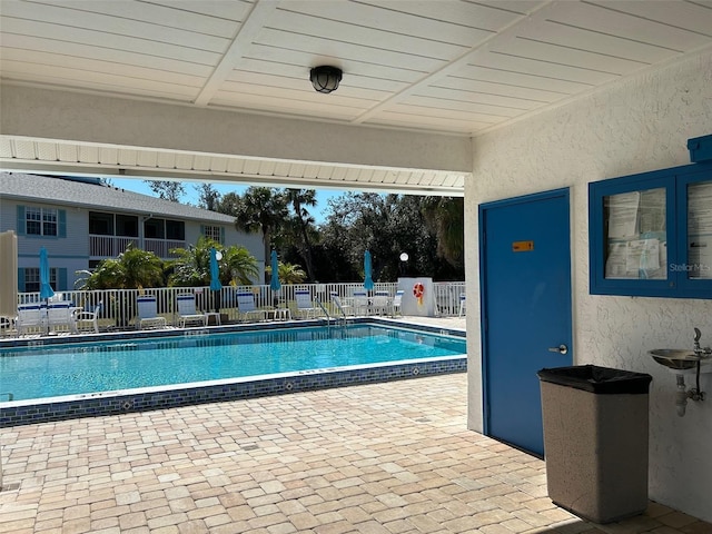 pool with a sink, a patio, and fence