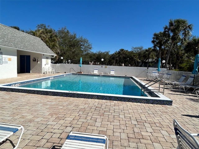 pool with a patio and fence