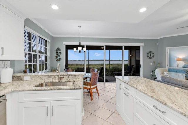 kitchen featuring light tile patterned floors, ornamental molding, a peninsula, white cabinetry, and a sink