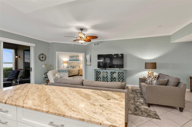 living room with visible vents, crown molding, and light tile patterned floors