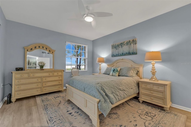 bedroom featuring ceiling fan, light wood finished floors, and baseboards