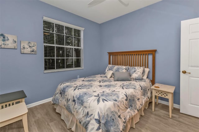 bedroom featuring a ceiling fan, baseboards, and wood finished floors