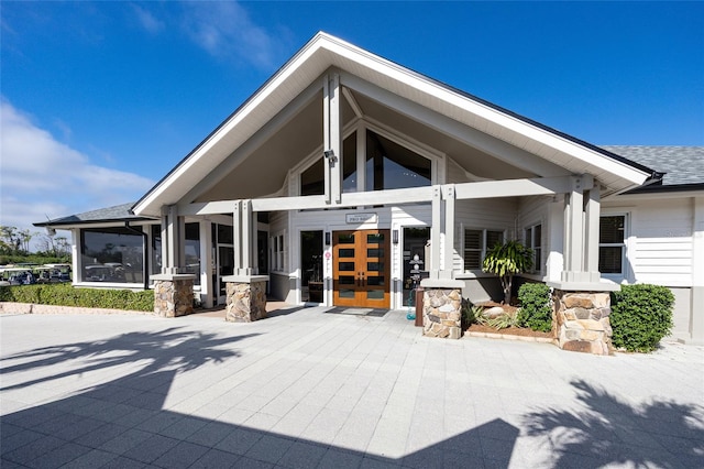 exterior space featuring french doors and roof with shingles