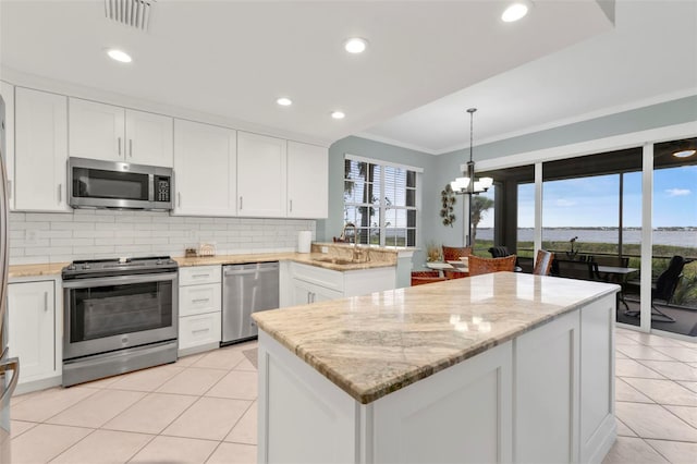 kitchen featuring stainless steel appliances, backsplash, white cabinetry, plenty of natural light, and a peninsula