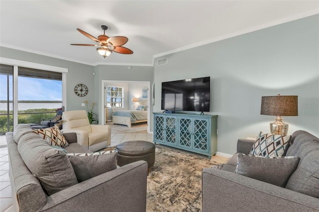 living room with visible vents, baseboards, a ceiling fan, tile patterned floors, and crown molding