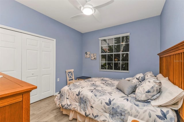 bedroom featuring light wood finished floors, ceiling fan, and a closet