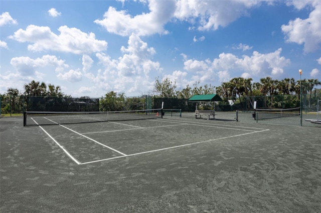 view of tennis court featuring fence