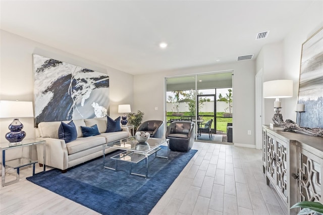 living area featuring light wood-style floors, baseboards, and visible vents