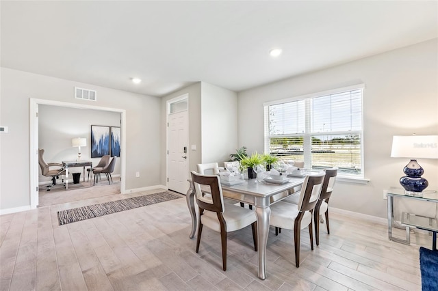 dining space with light wood finished floors, recessed lighting, visible vents, and baseboards