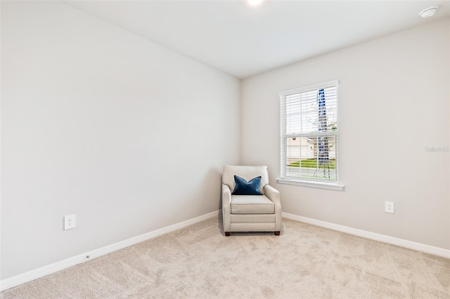 sitting room featuring baseboards and light colored carpet