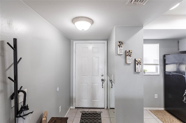 foyer entrance with visible vents, baseboards, and light tile patterned floors