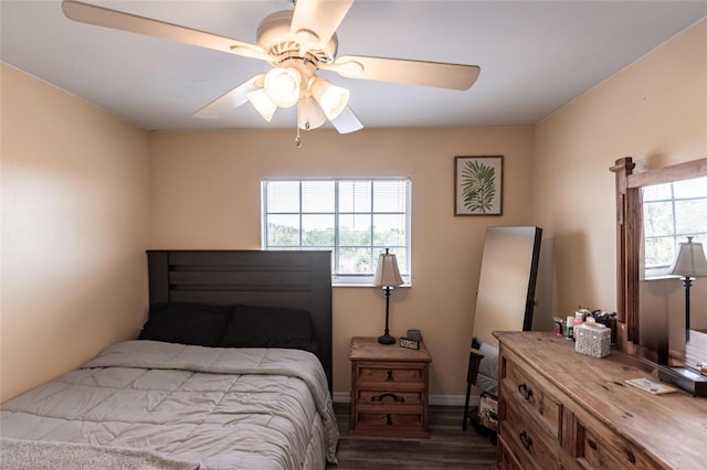 bedroom with a ceiling fan, dark wood finished floors, and baseboards