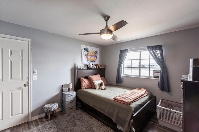 bedroom with baseboards, a ceiling fan, and dark wood-style flooring