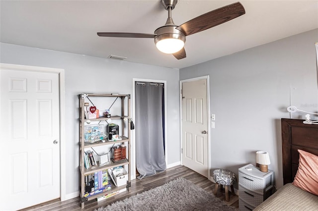 bedroom with baseboards, visible vents, a ceiling fan, and dark wood-type flooring