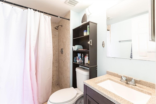 bathroom featuring toilet, a shower stall, visible vents, and vanity