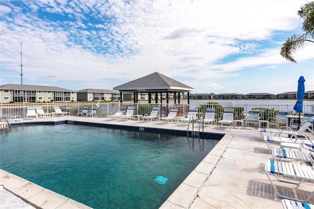 community pool with fence, a patio, and a gazebo