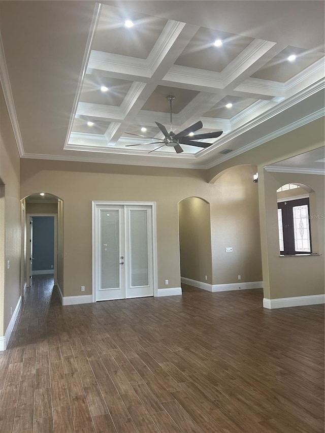 empty room featuring arched walkways, dark wood-style flooring, coffered ceiling, and ceiling fan