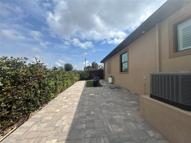 view of patio with a fenced backyard and central AC unit