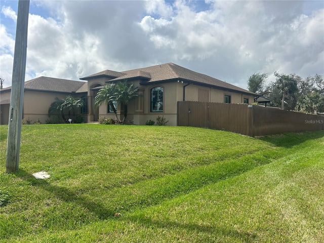 view of property exterior featuring fence, a lawn, and stucco siding