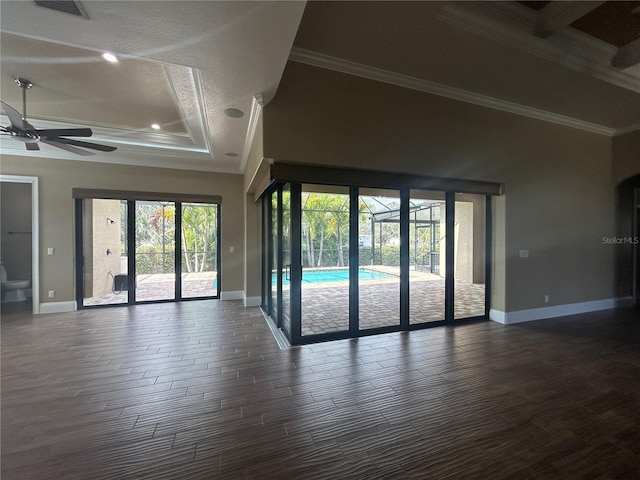 empty room with dark wood-style floors, crown molding, and baseboards