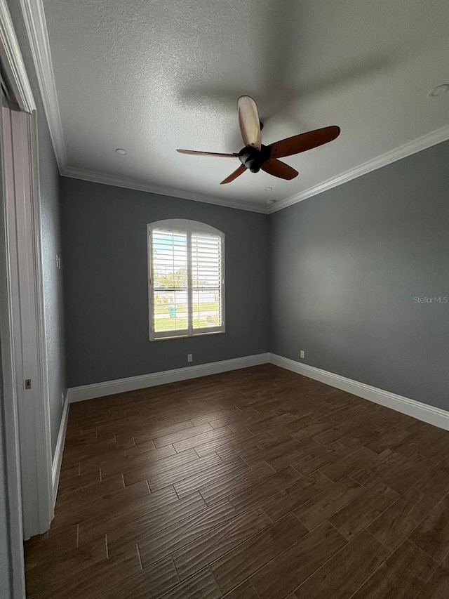 unfurnished room with baseboards, a textured ceiling, ornamental molding, and dark wood-style flooring