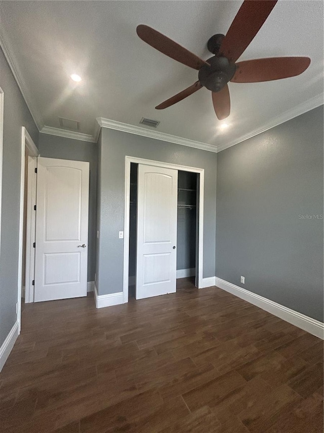 unfurnished bedroom with ornamental molding, dark wood-type flooring, a closet, and visible vents