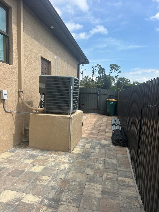 view of patio with central air condition unit, a gate, and fence