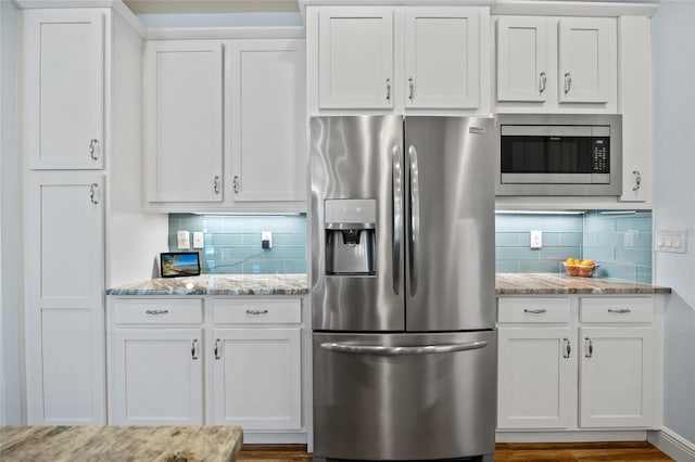 kitchen featuring appliances with stainless steel finishes, light stone counters, and white cabinets