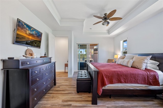 bedroom with multiple windows, a raised ceiling, and crown molding