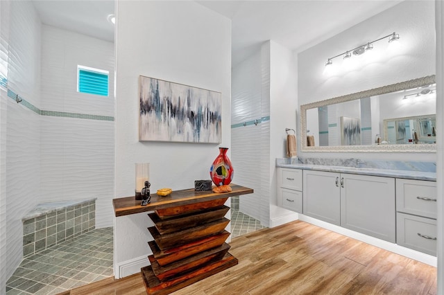 full bath with a walk in shower, wood finished floors, and vanity