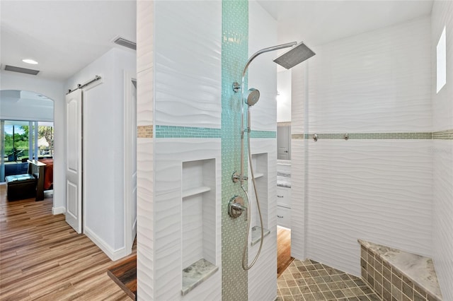 ensuite bathroom featuring wood finished floors, visible vents, ensuite bathroom, and walk in shower