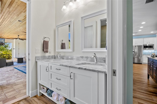 bathroom with wood finished floors, a sink, visible vents, and recessed lighting