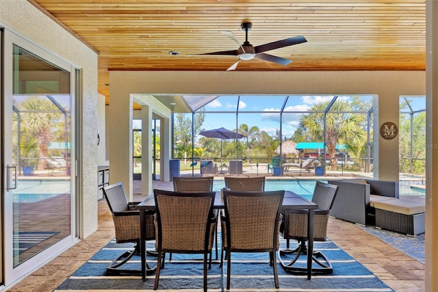 dining room with wood ceiling, a sunroom, a healthy amount of sunlight, and a textured wall