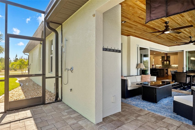 view of patio with ceiling fan, a lanai, and an outdoor living space