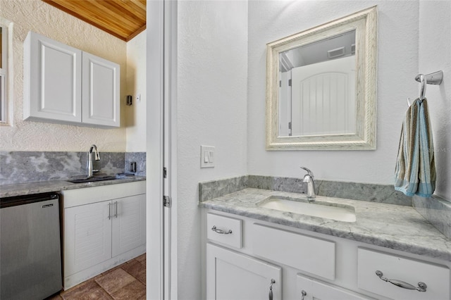 bathroom featuring a textured wall and vanity