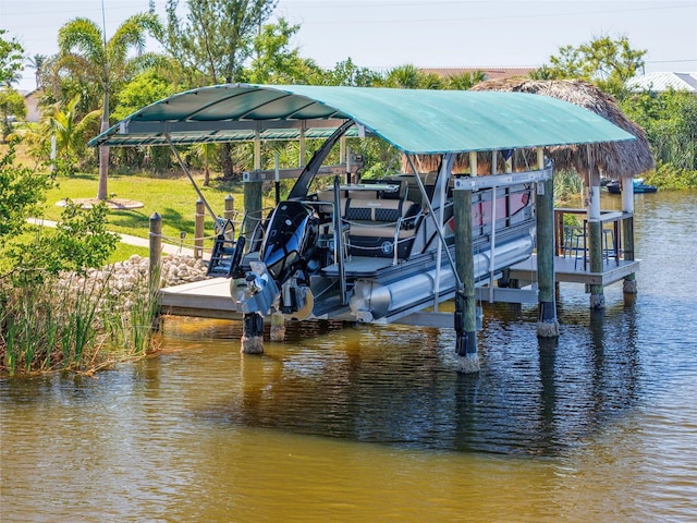 view of dock with a water view, boat lift, and a yard