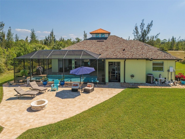 rear view of property with a patio, glass enclosure, a fire pit, a yard, and an outdoor pool