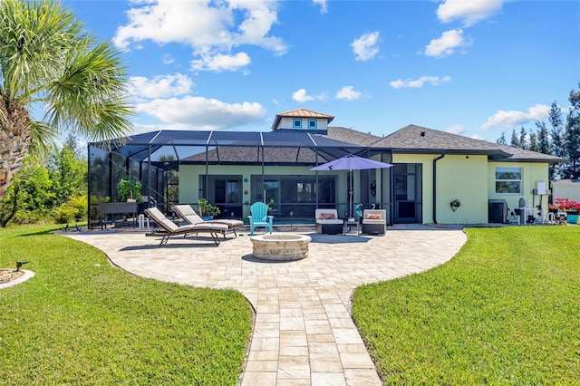 rear view of property featuring a fire pit, glass enclosure, a lawn, and a patio area